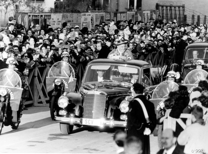 Pope John XXIII standing up on a drive through the streets in his Mercedes-Benz 300 d landaulet