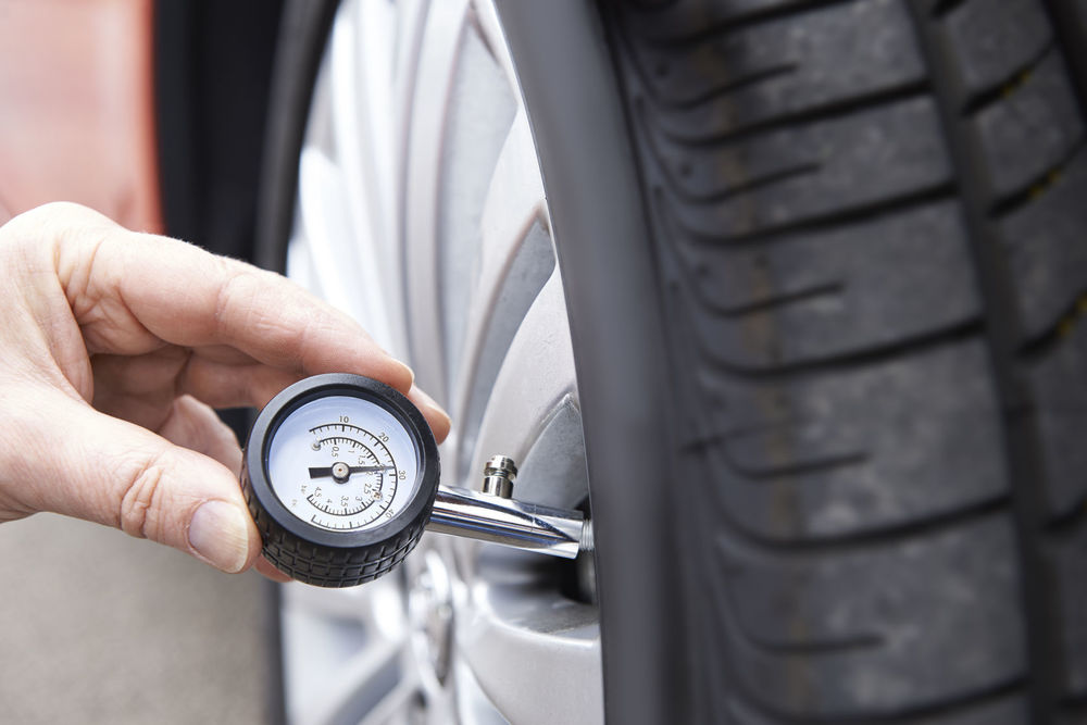 46635339 – close-up of man checking car tyre pressure with gauge