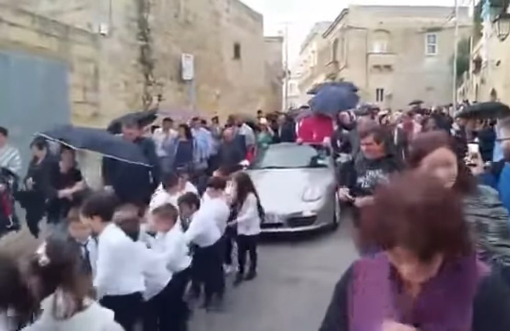 Padre em Malta transportado em Porsche puxado por 50 crianças