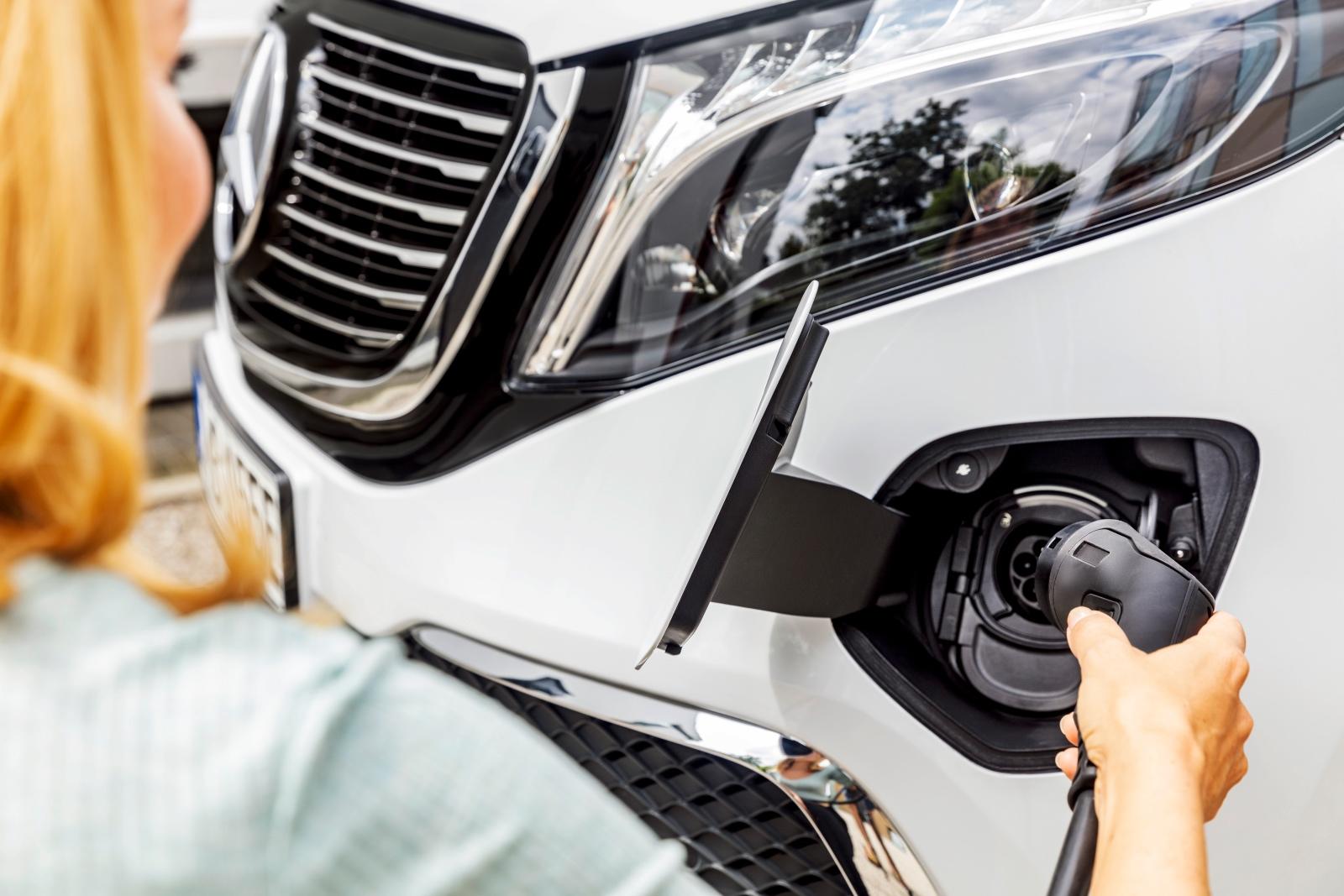 Der neue Mercedes-Benz EQV (Stromverbrauch kombiniert: 27,0 kWh/100 km; CO2-Emissionen kombiniert: 0 g/km, Angaben vorläufig) – Exterieur, Bergkristallweiß metallic, Black Panel-Kühlergrill mit Chromlamellen, Ladeanschluss im Stoßfänger // The new Mercedes-Benz EQV (combined power consumption: 27.0 kWh/100 km; combined CO2 emissions: 0 g/km, provisional figures) – Exterior, Mountain crystal white metallic, black panel radiator grille with chrome fins, charging connection in the bumper