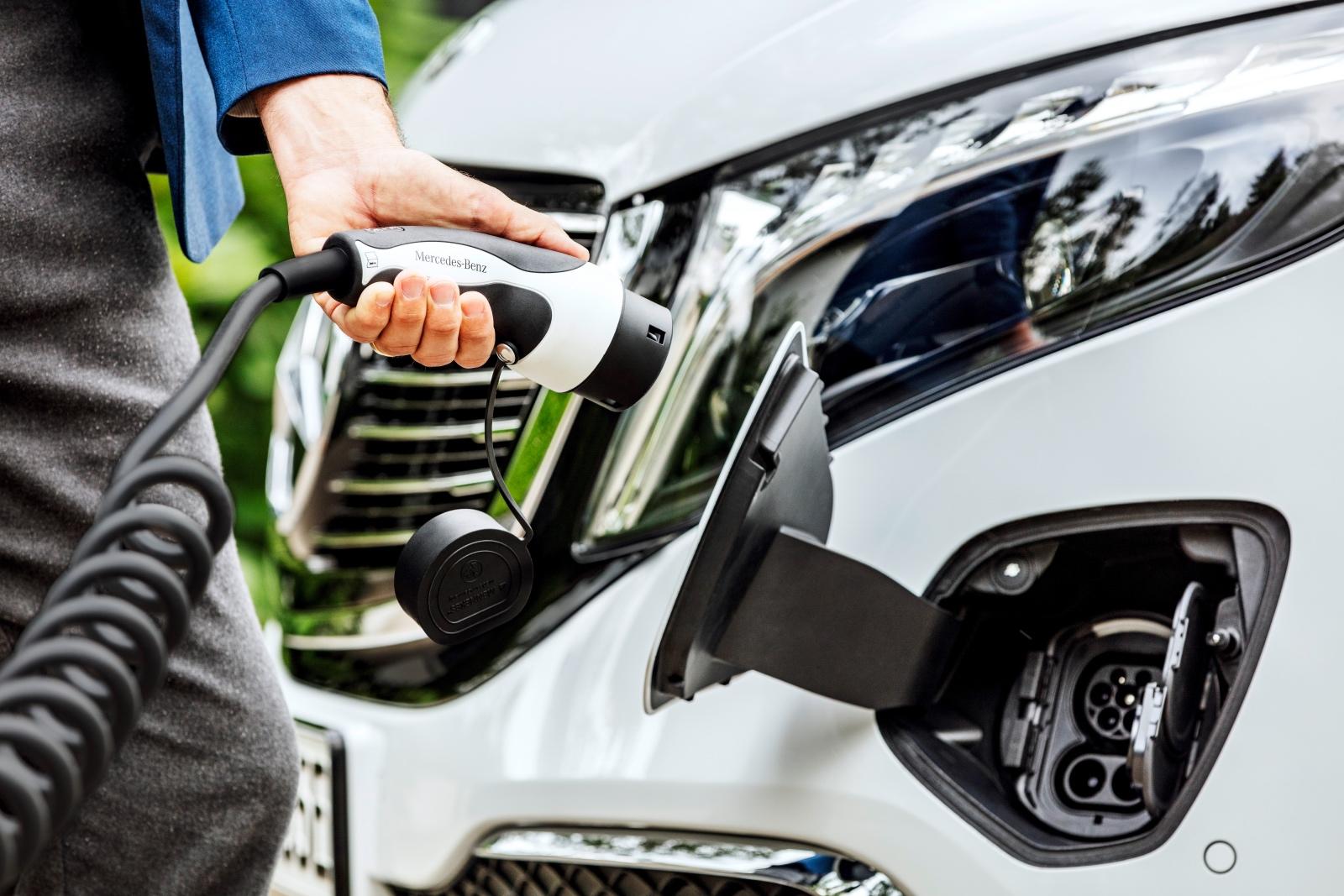 Der neue Mercedes-Benz EQV (Stromverbrauch kombiniert: 27,0 kWh/100 km; CO2-Emissionen kombiniert: 0 g/km, Angaben vorläufig) – Exterieur, Bergkristallweiß metallic, Black Panel-Kühlergrill mit Chromlamellen, Ladeanschluss im Stoßfänger // The new Mercedes-Benz EQV (combined power consumption: 27.0 kWh/100 km; combined CO2 emissions: 0 g/km, provisional figures) – Exterior, Mountain crystal white metallic, black panel radiator grille with chrome fins, charging connection in the bumper