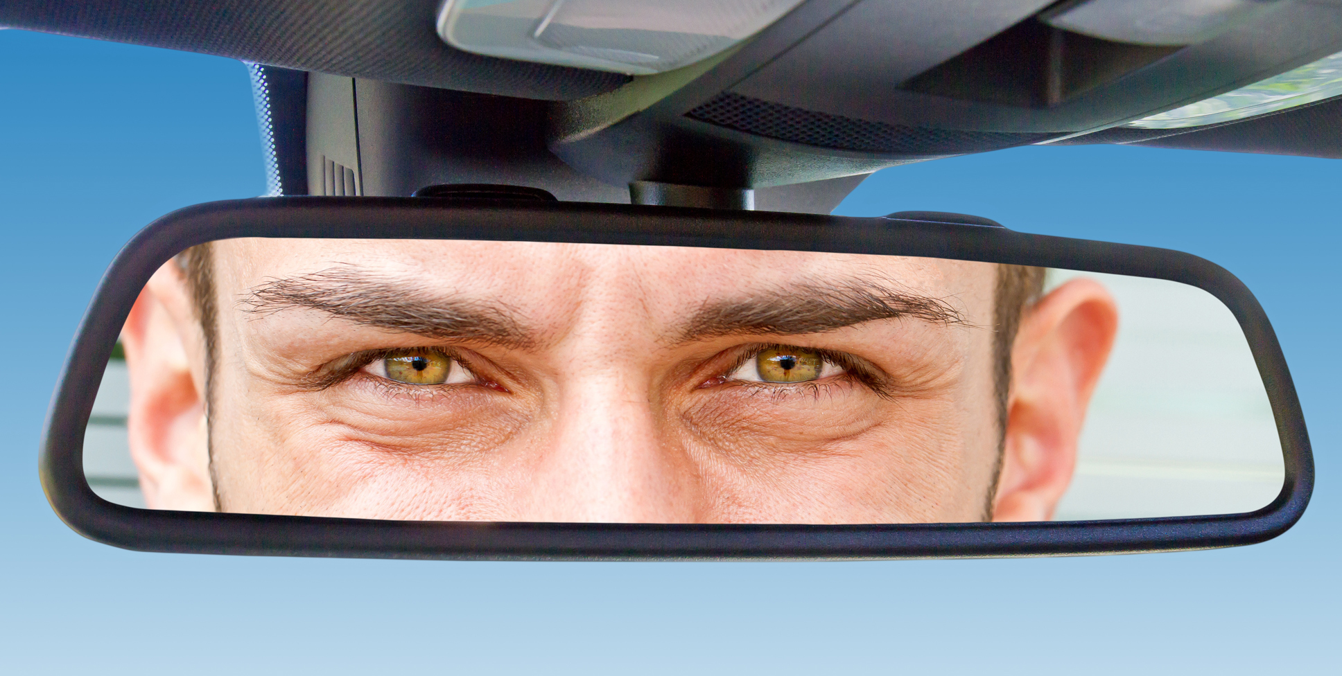 Водитель смотрит в зеркало. Глаза в зеркале автомобиля. Глаза в автомобильном зеркале.